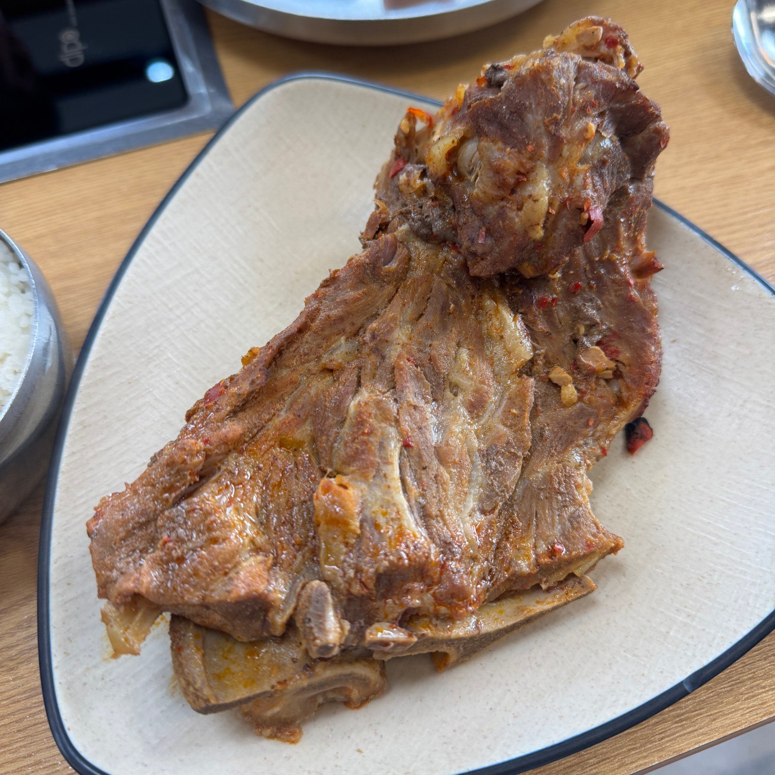 A large cooked pork backbone piece on a separate plate beside the meal